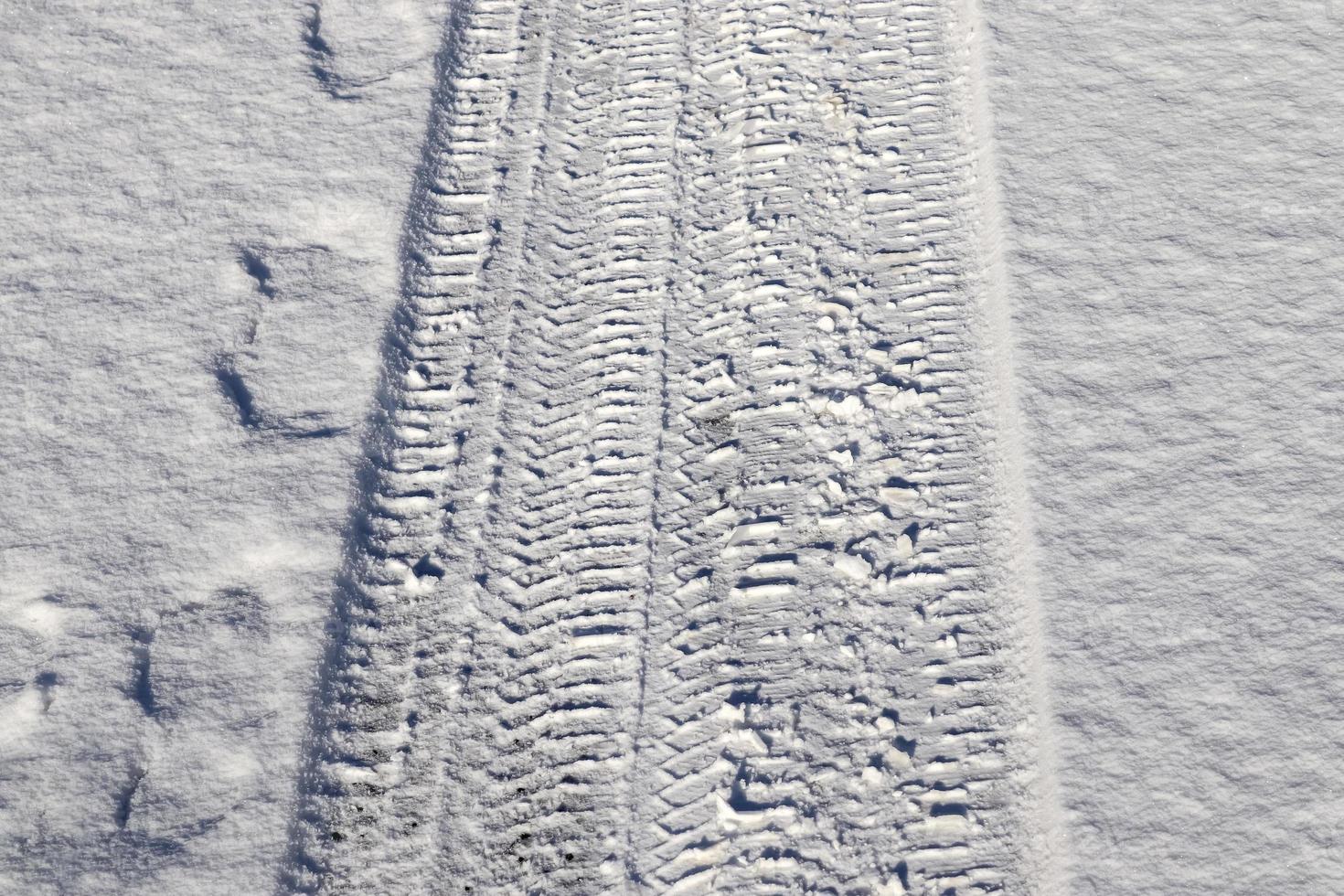 Tire Tracks on snow covered streets in a close up view. photo