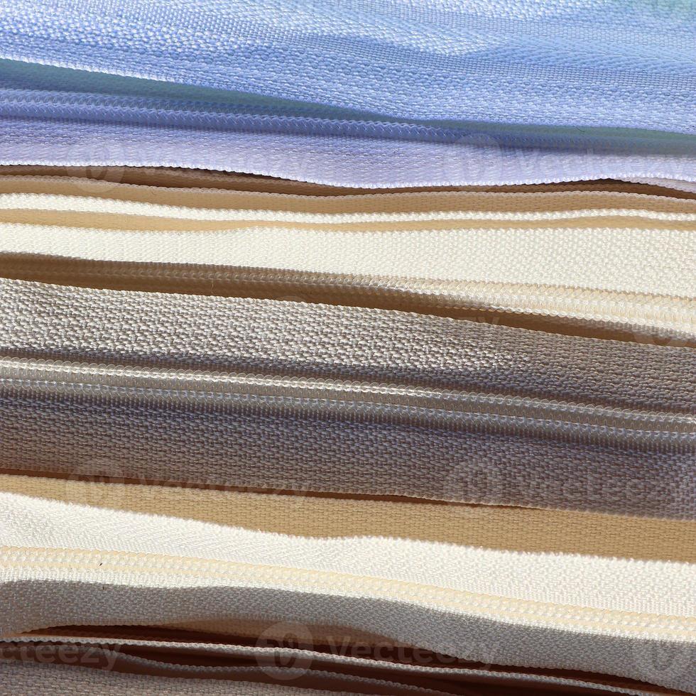Detailed close up view on samples of cloth and fabrics in different colors found at a fabrics market photo