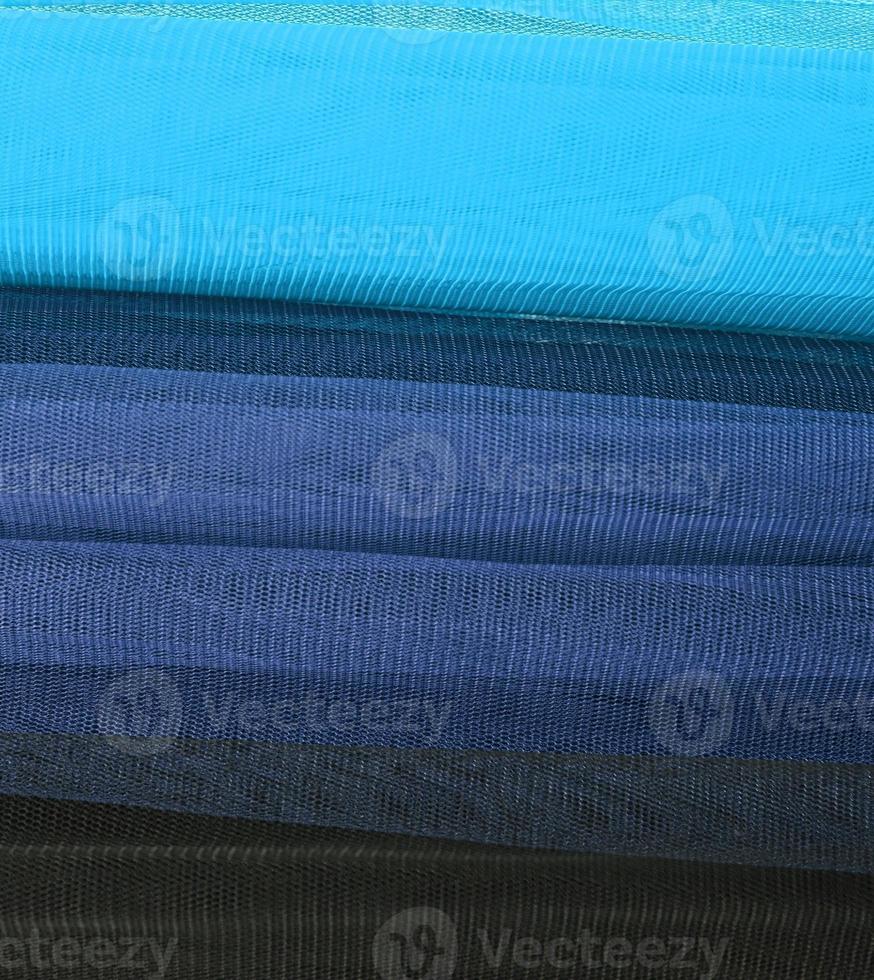 Detailed close up view on samples of cloth and fabrics in different colors found at a fabrics market photo