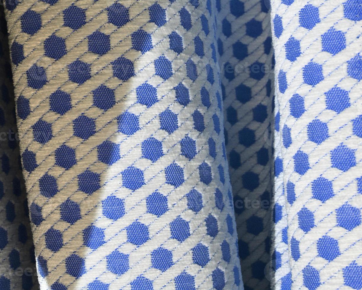 Detailed close up view on samples of cloth and fabrics in different colors found at a fabrics market photo