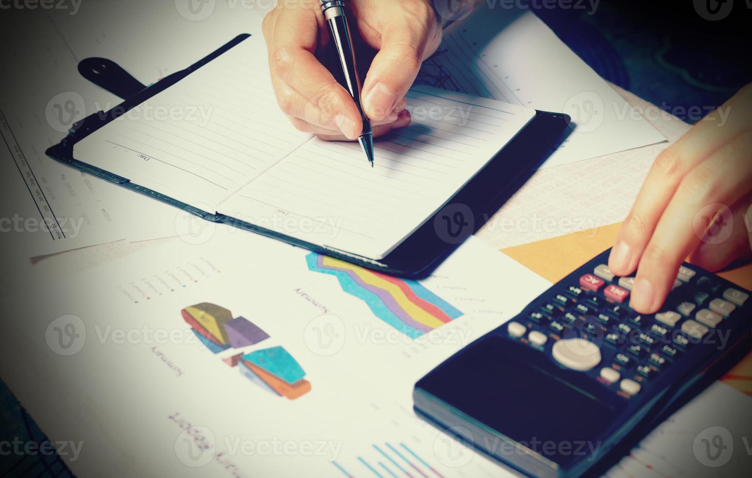 Calculator with hand man writing make note with doing finance and calculate on desk about cost at home office. photo