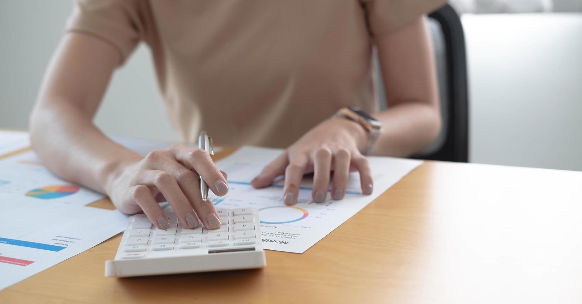 Close up businessman hand using calculator and writing make note with calculate about finance accounting.finance accounting concept photo