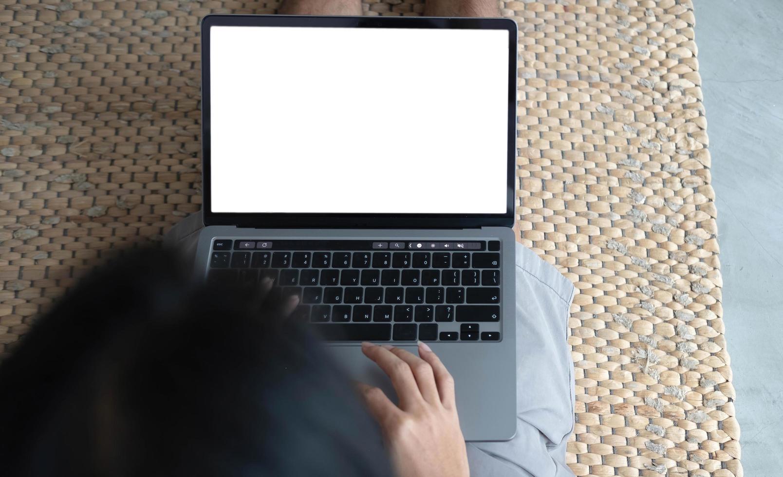 Woman using laptop with blank mock up white empty screen typing on computer at home, mockup copyspace display for ad, job search, study online shopping, website page, e-banking, over shoulder view photo