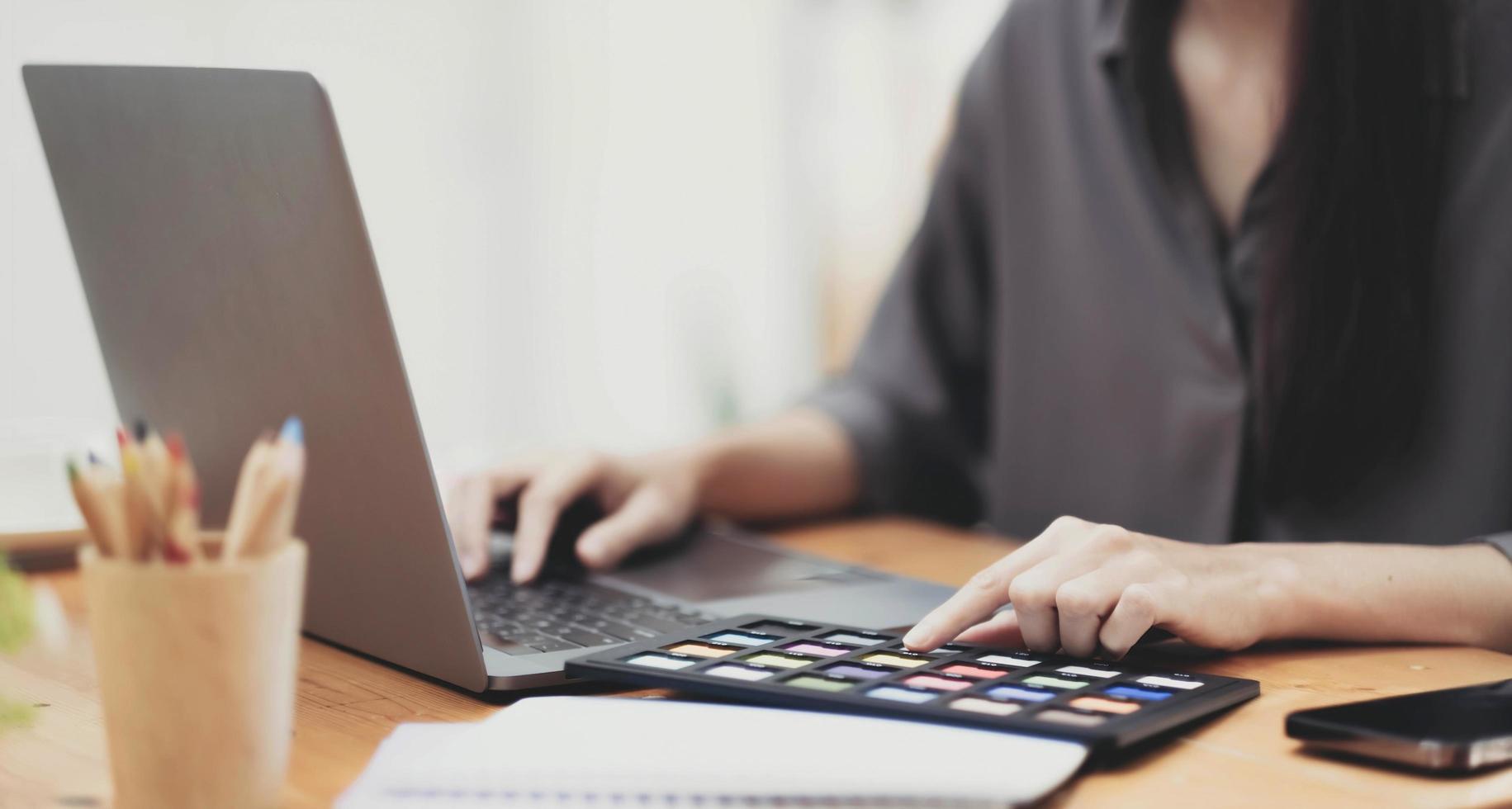 Young asian female designer using graphics tablet while working with computer at studio or office. photo