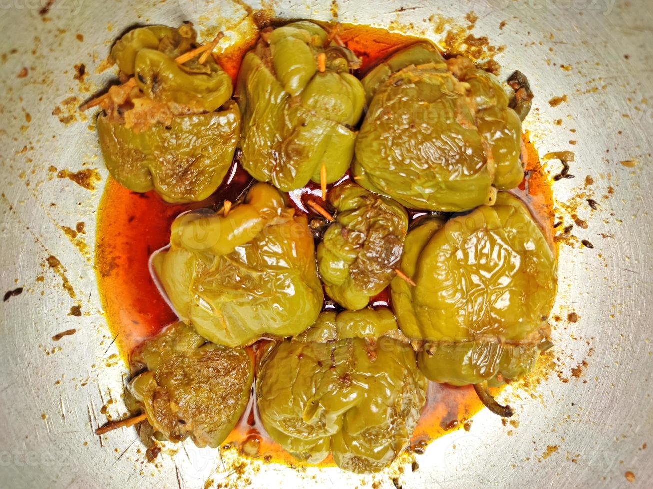 Boiled and spicy potatoes stuffed Shimla Mirch ki Sabzi - stuffed spicy capsicum curry - placed on a silver coloured wok. photo