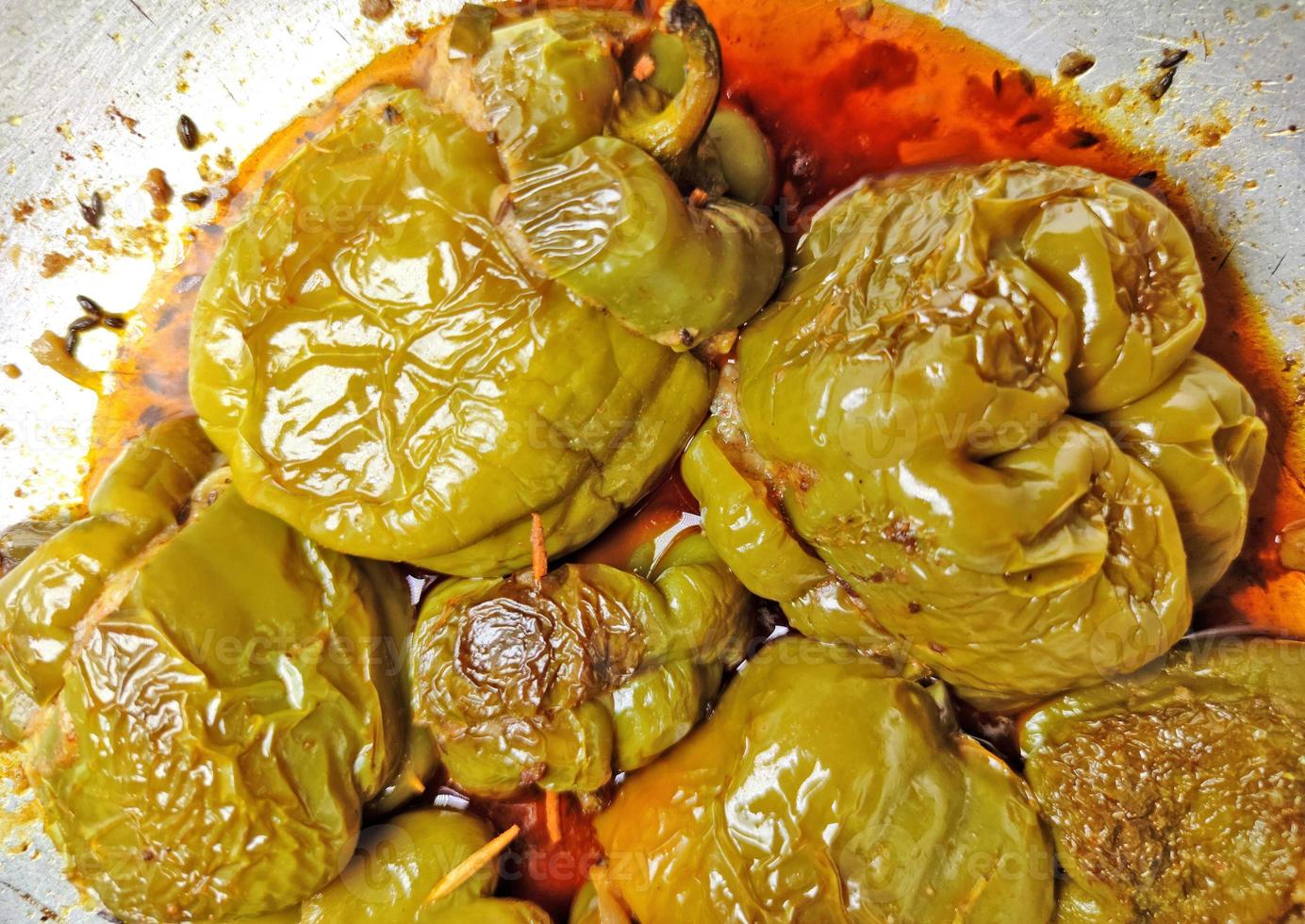 Boiled and spicy potatoes stuffed Shimla Mirch ki Sabzi - stuffed spicy capsicum curry - placed on a silver coloured wok. photo