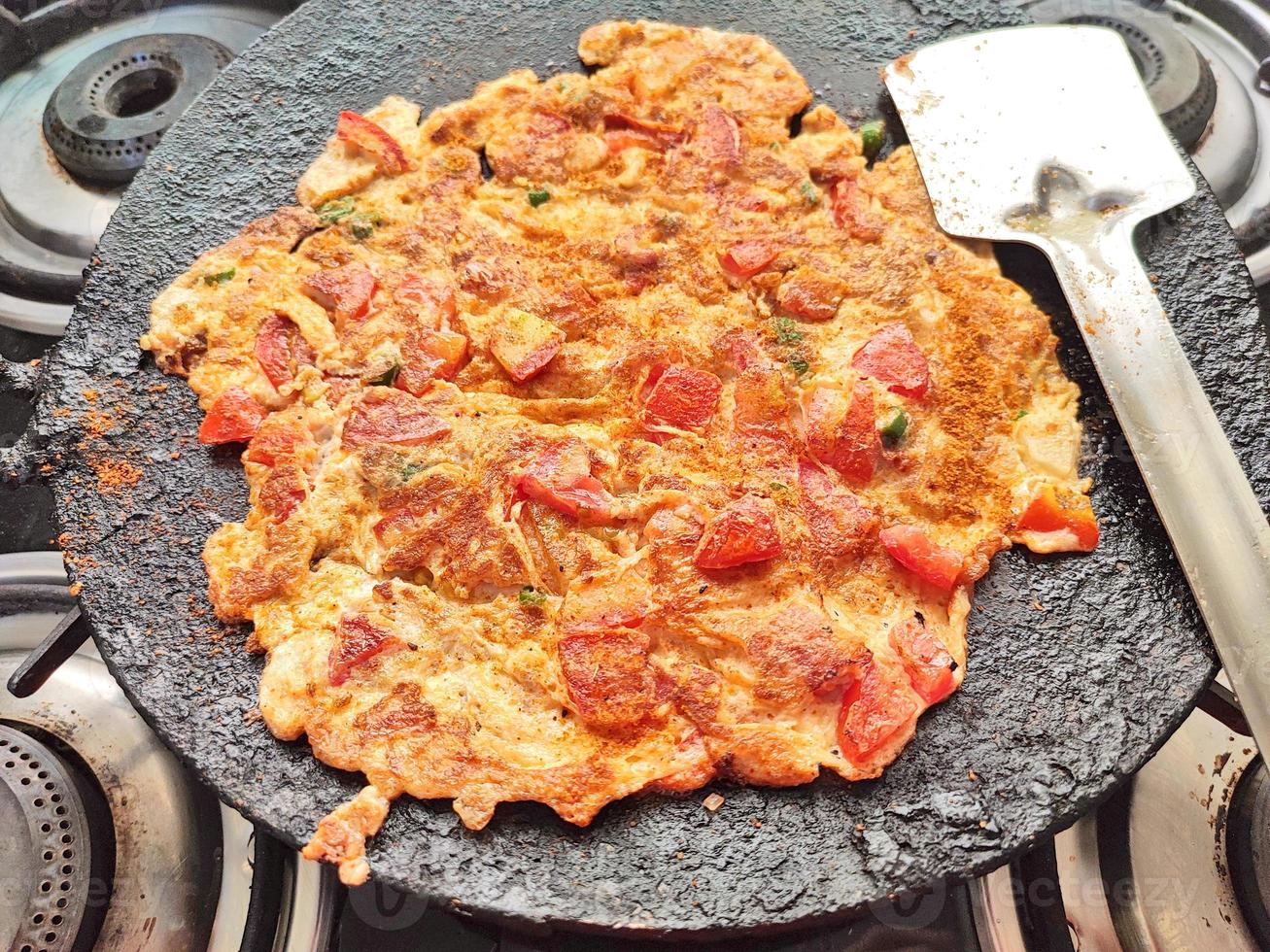 Tomato omelette kept ready by cooking on a gas pan photo