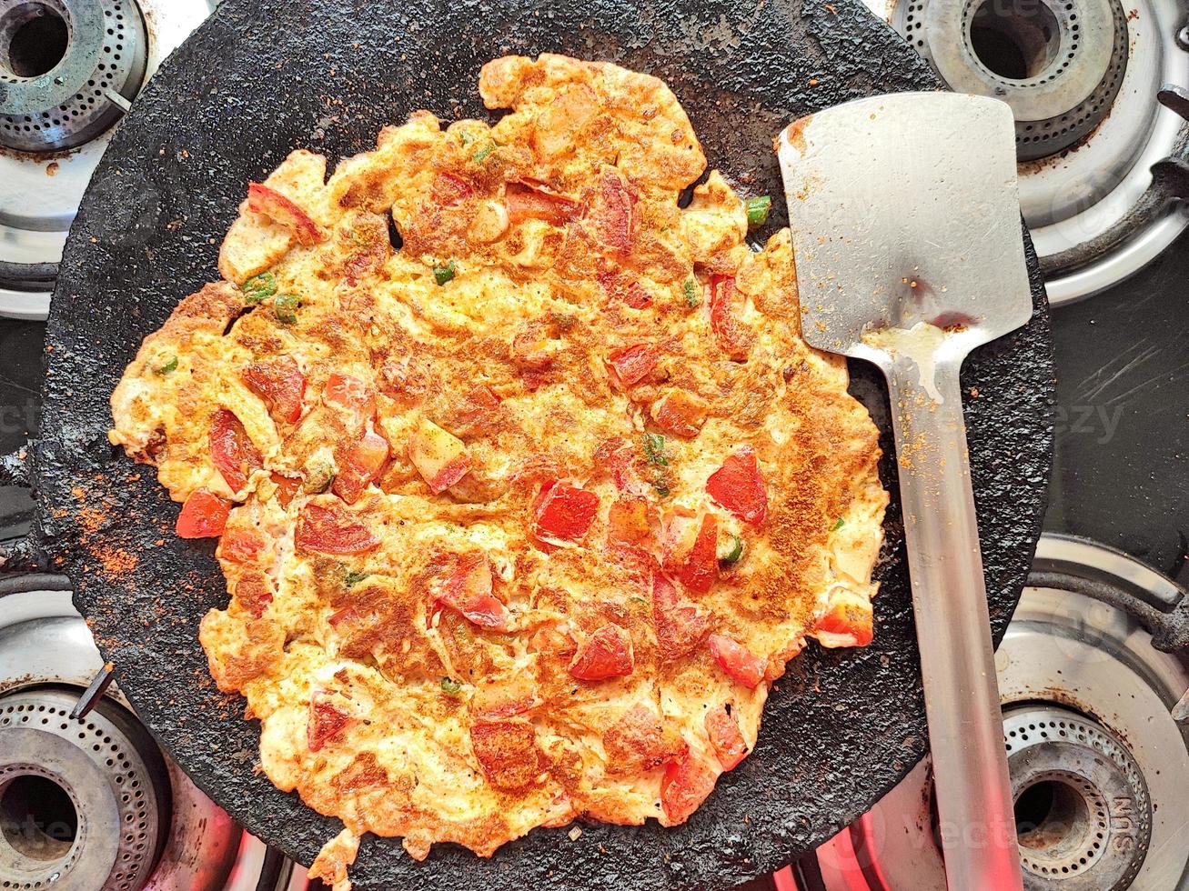 tortilla de tomate preparada cocinando en una sartén de gas foto