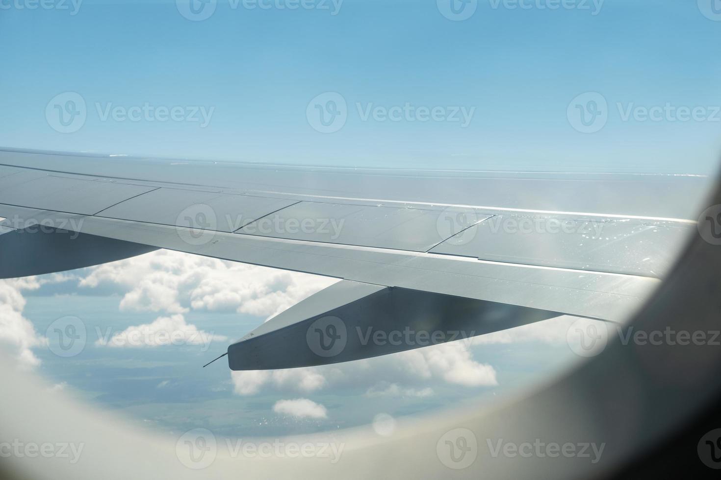 View of the wing of an airplane and the sky with clouds photo
