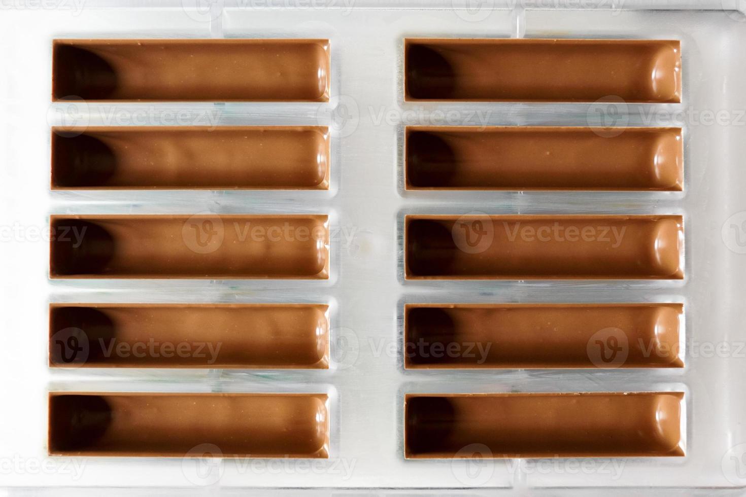 Chocolate poured into plastic mold. Frame for filling chocolate bars photo