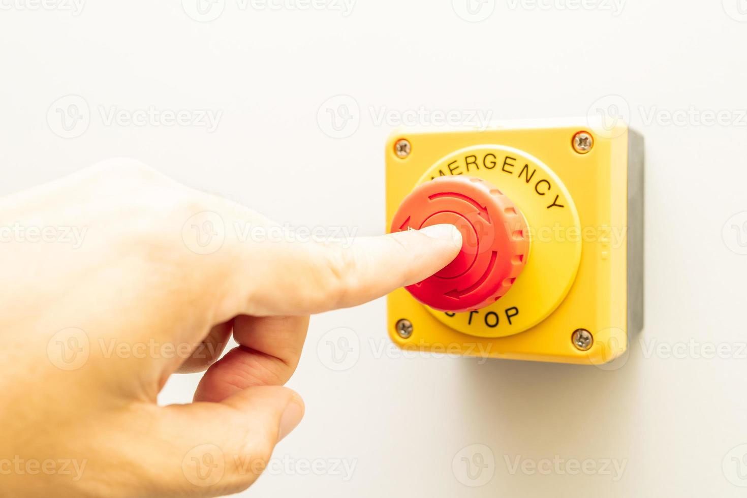 Stop Button and the Hand of Worker About to Press it. emergency stop button. Big Red emergency button or stop button for manual pressing. photo