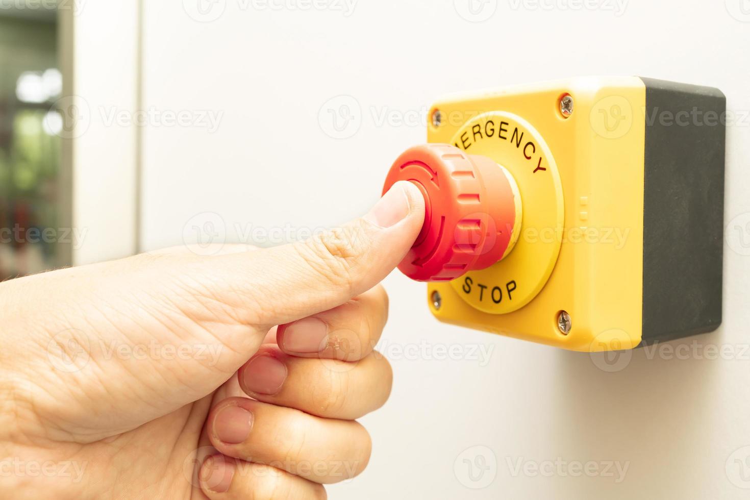 Stop Button and the Hand of Worker About to Press it. emergency stop button. Big Red emergency button or stop button for manual pressing. photo