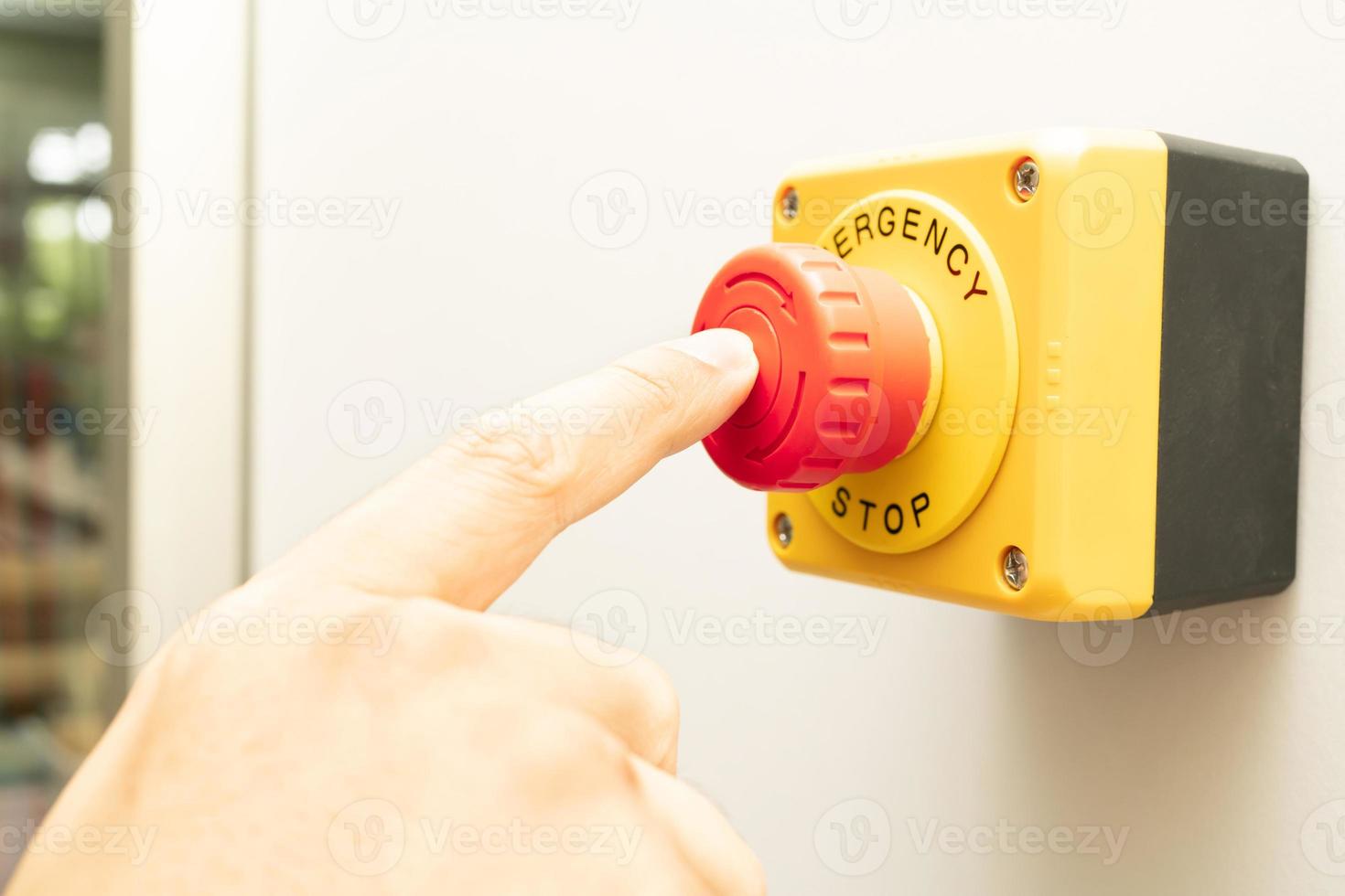 Stop Button and the Hand of Worker About to Press it. emergency stop button. Big Red emergency button or stop button for manual pressing photo