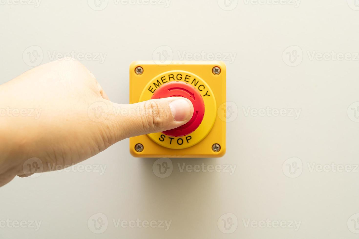Stop Button and the Hand of Worker About to Press it. emergency stop button. Big Red emergency button or stop button for manual pressing. photo