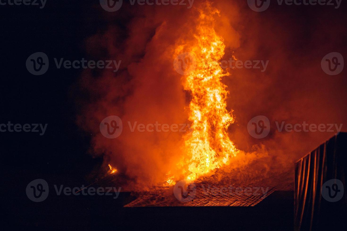 House on fire at night. Strong fire in a small village photo