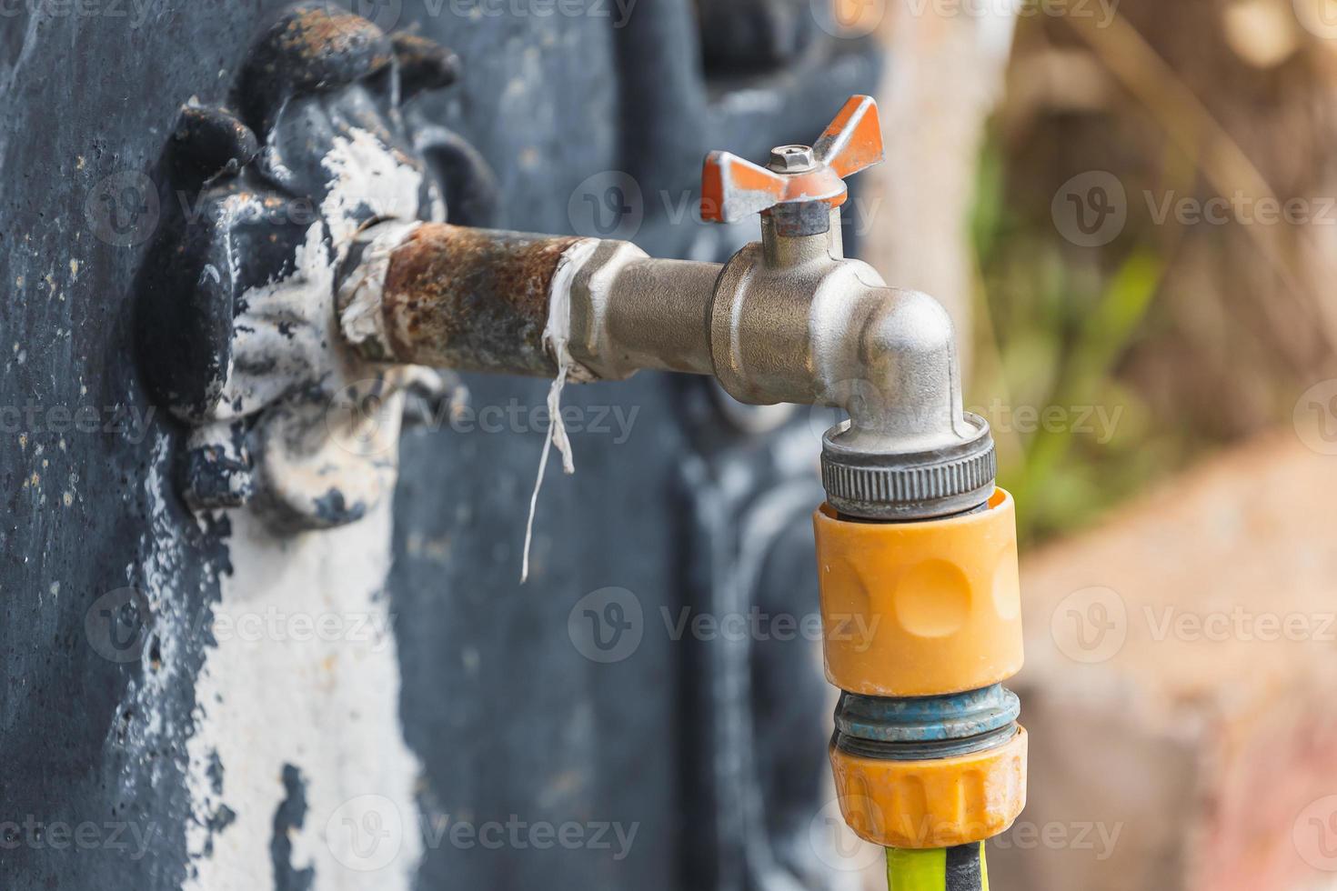 close-up of a faucet with a plastic hose in an outdoor washbasin photo