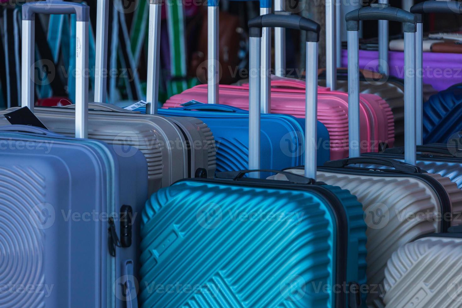 Bright  colorful rows of suitcases with extended handles and different sizes are on sale in front of the store photo