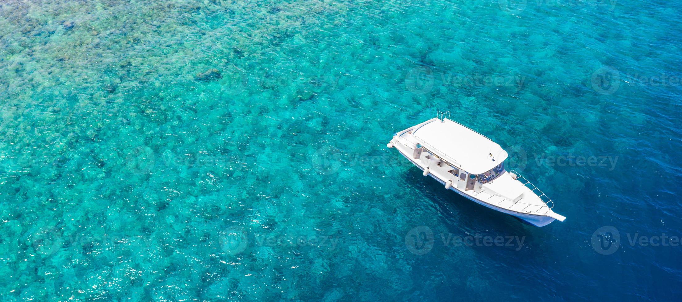 Luxury small yacht anchoring in shallow water, ocean lagoon coral reef in Maldives. Snorkel diving boat, outdoor activity, summer recreation photo