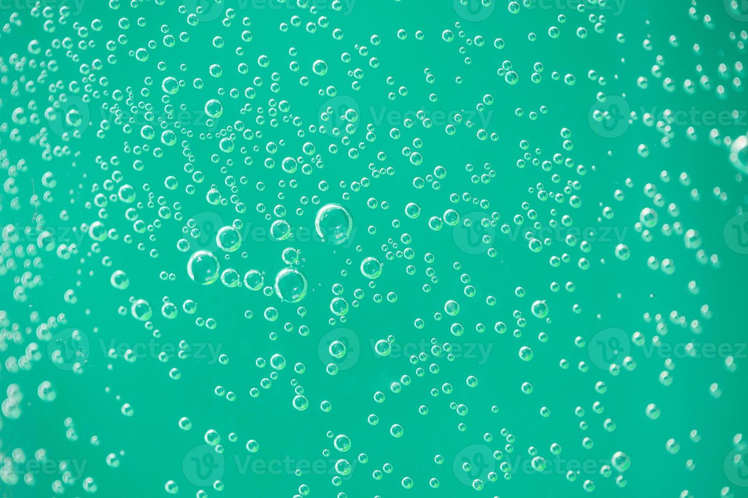 Water drops on glass on green background. Abstract relaxing background pattern photo