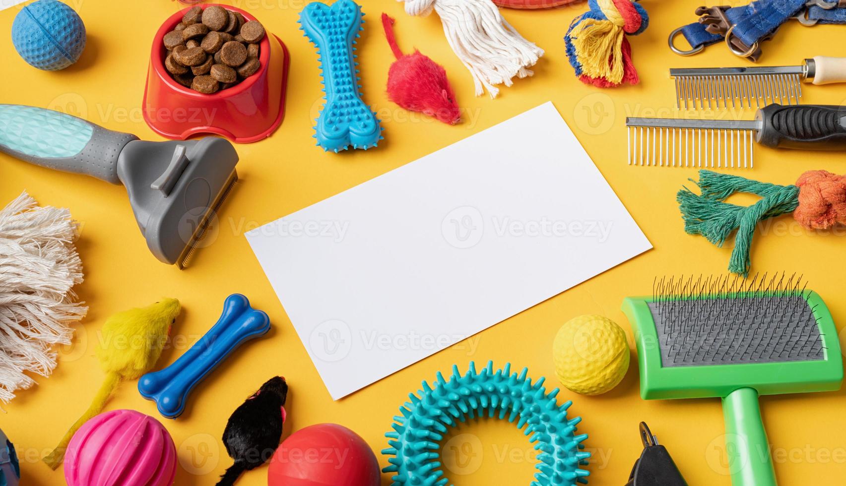 Pet care concept, various pet accessories and tools on yellow background with blank paper, high angle photo