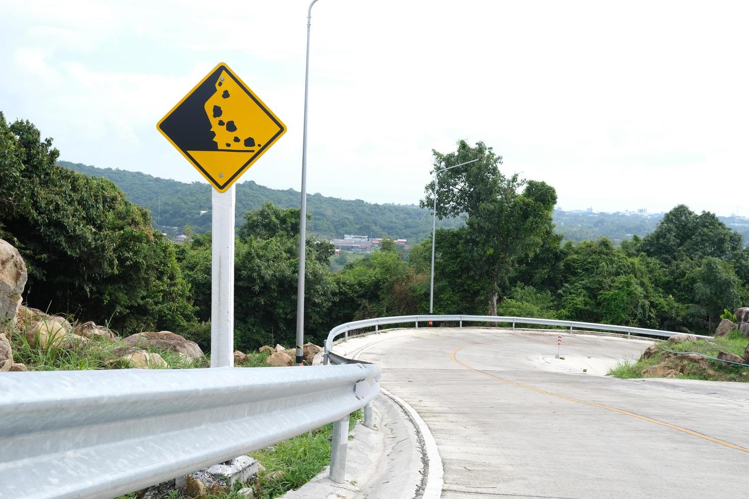 Señal de carretera de caída de piedra de advertencia en carretera de montaña. foto