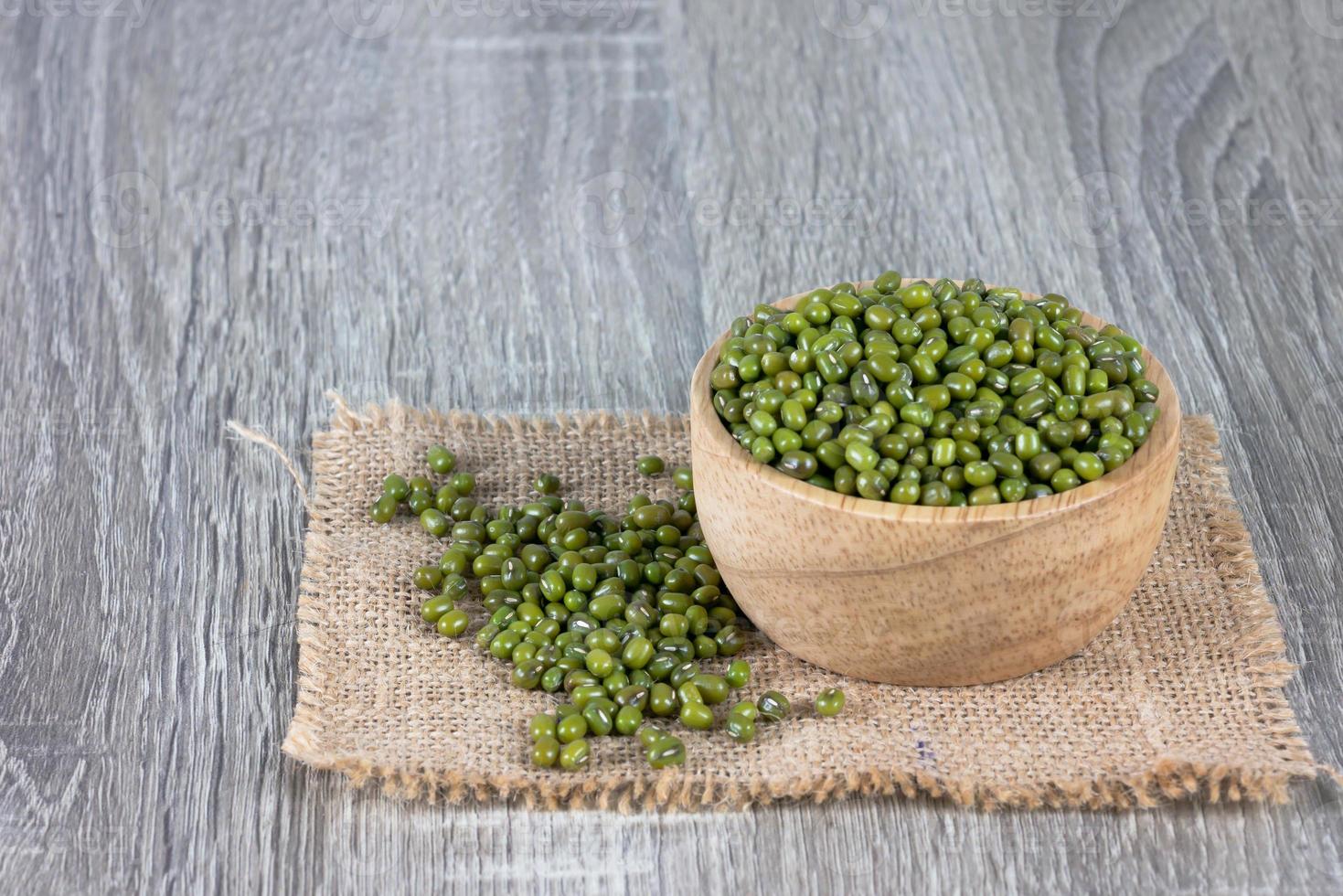 Green beans overflow wooden bowls and pile on the woven sack photo