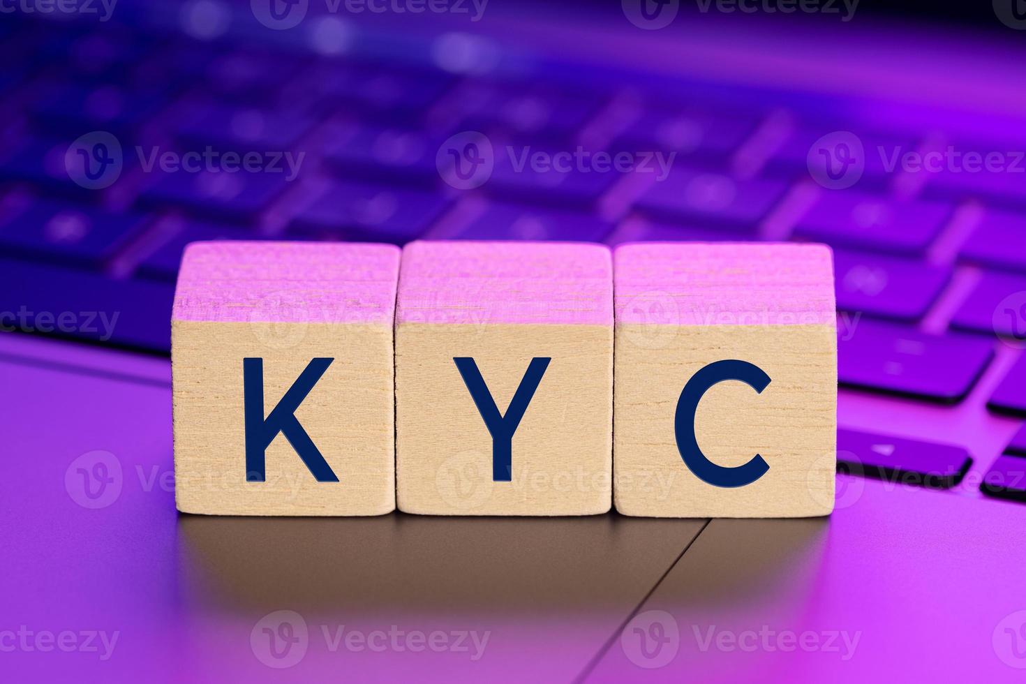 KYC word on wooden blocks on laptop with colorful lights. Online Know Your Customer concept photo