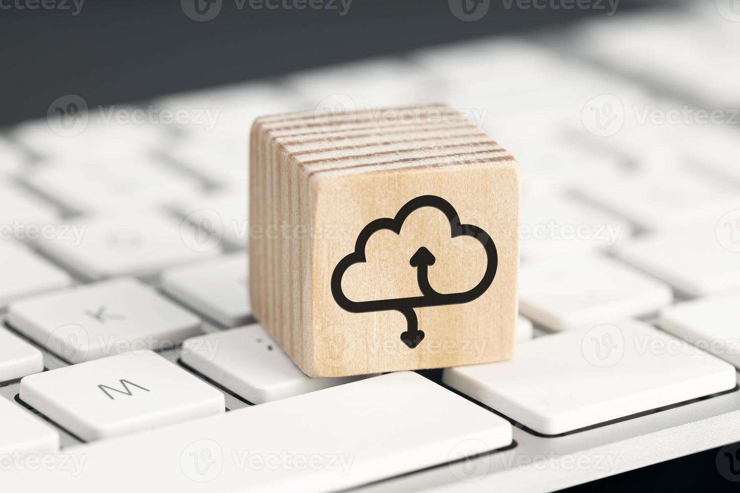 Cloud computing icon on wooden block on computer keyboard photo