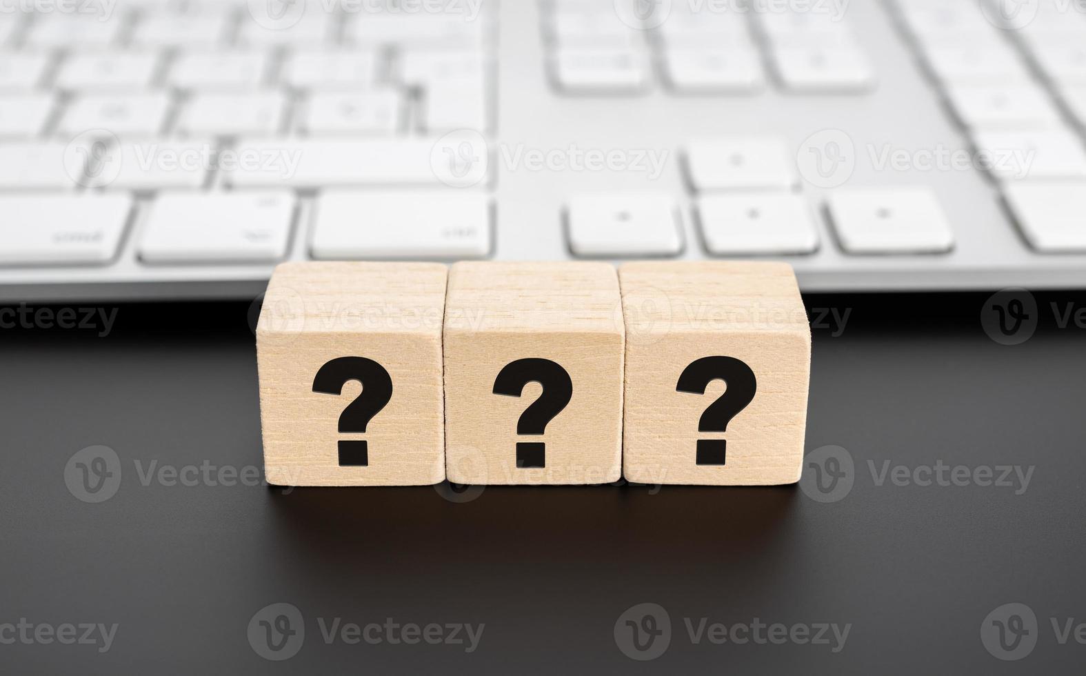 Questions Mark on wooden block and computer keyboard. FAQ Answer photo