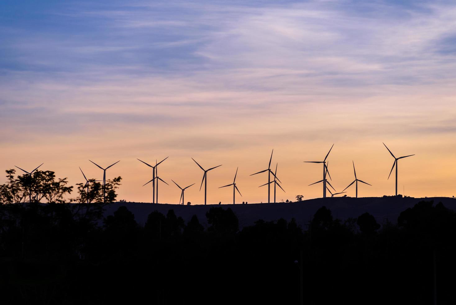 wind turbine on mountain making electric energy from wind at evening time photo