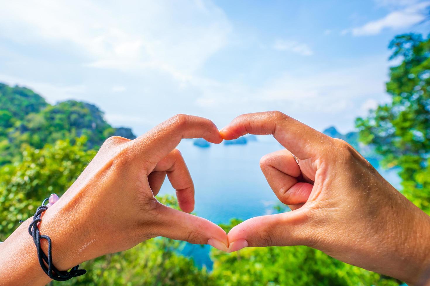 Heart shape made with hands of man and woman love symbol concept, Blurred background, Phi Phi Island, at  Krabi Province photo