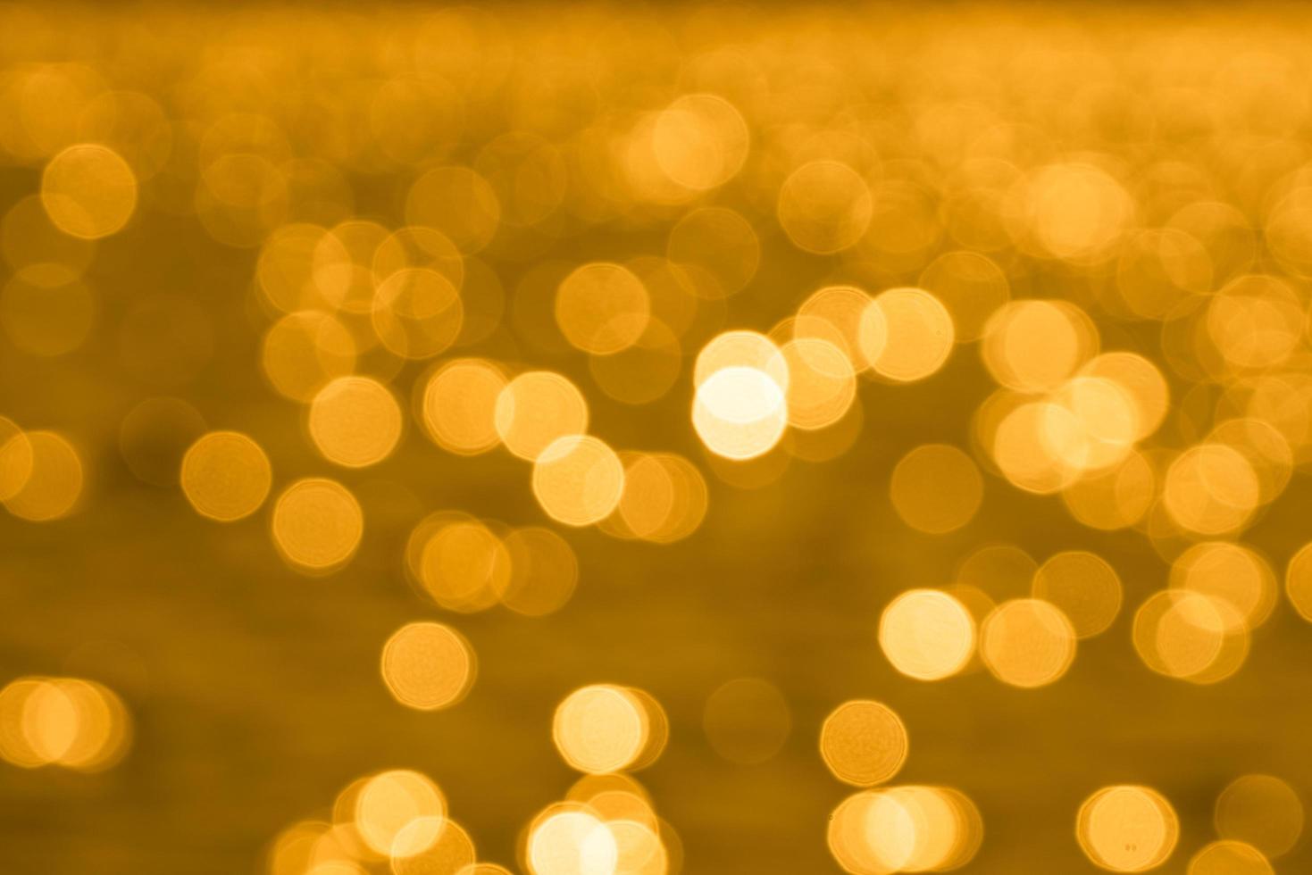 Bokeh light from reflection of golden water surface in the evening sunset photo