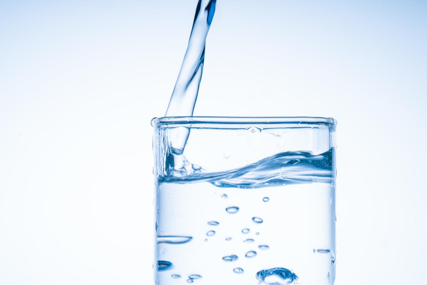 Ice cube fell into the glass of water. Water splashed from the clear glass. Fresh concept photo
