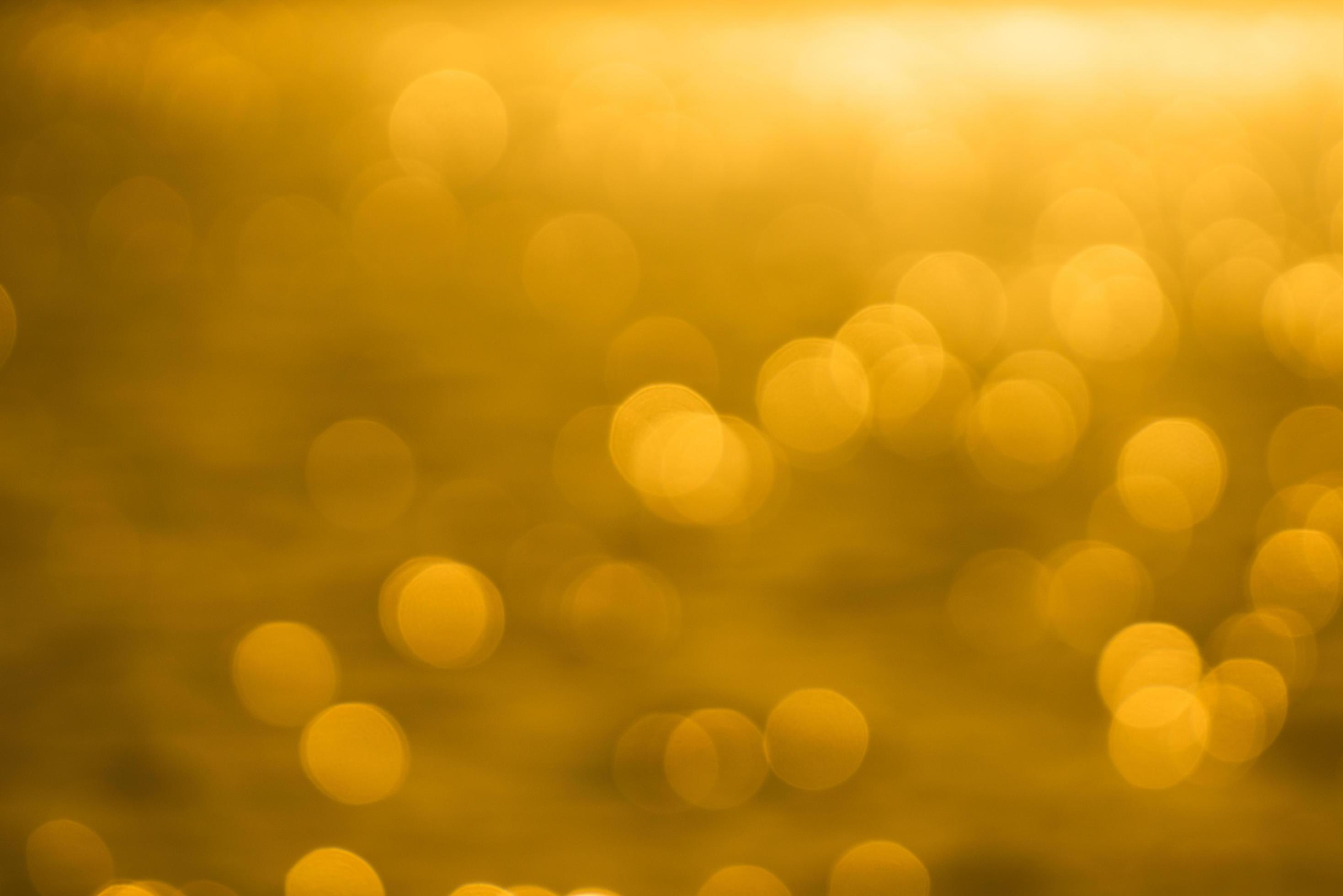 Bokeh light from reflection of golden water surface in the evening ...