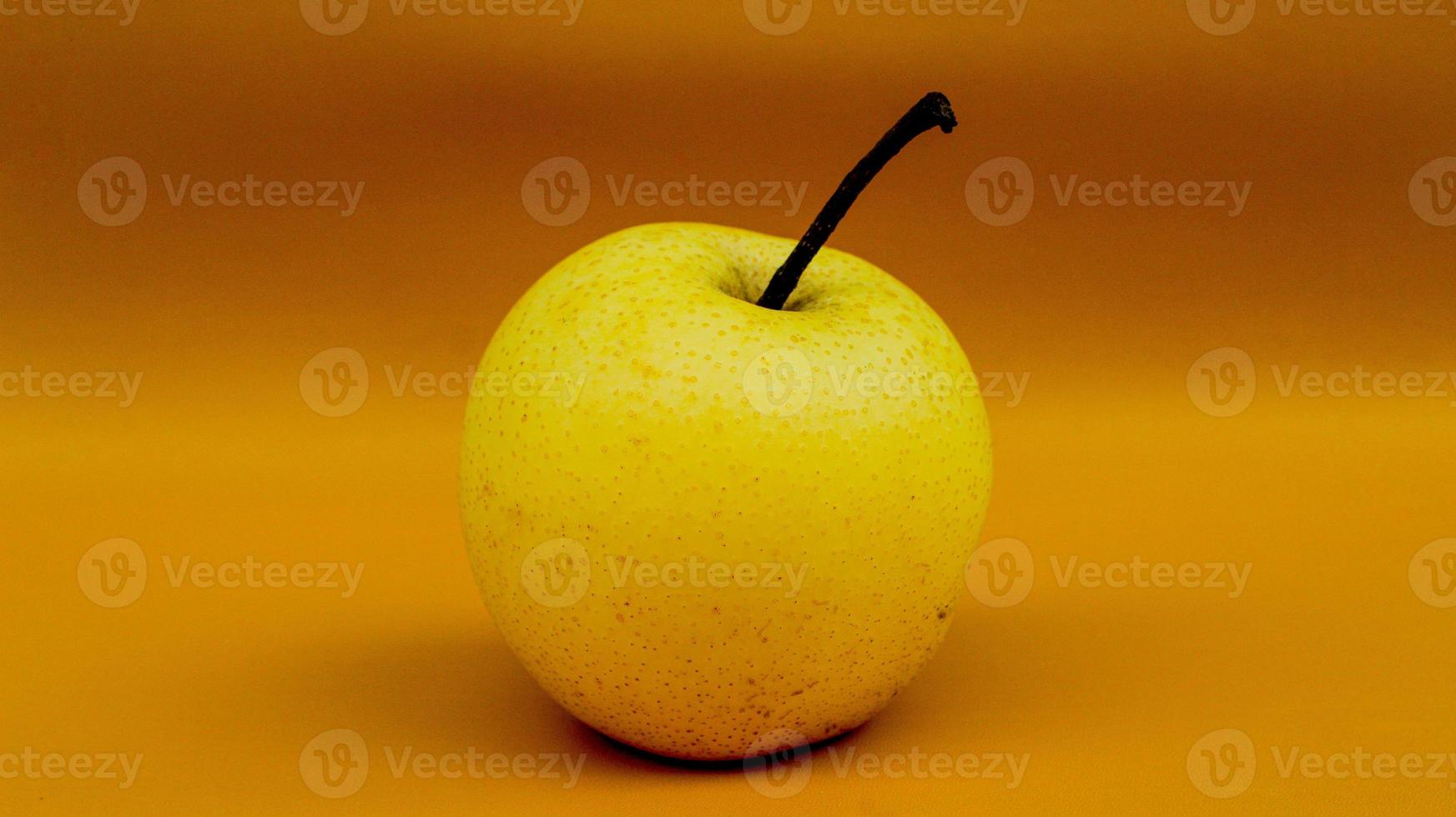 A pear with stem on orange background. A pear on isolated orange background. photo