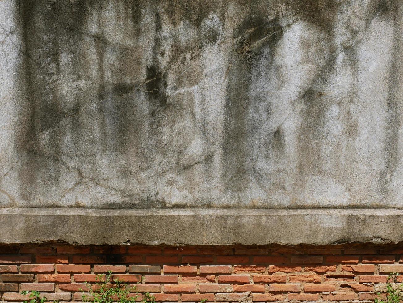 The old cement wall was weathered, the surface was scratched, the surface was scratched and damaged. For a mysterious retro-conservative background. photo