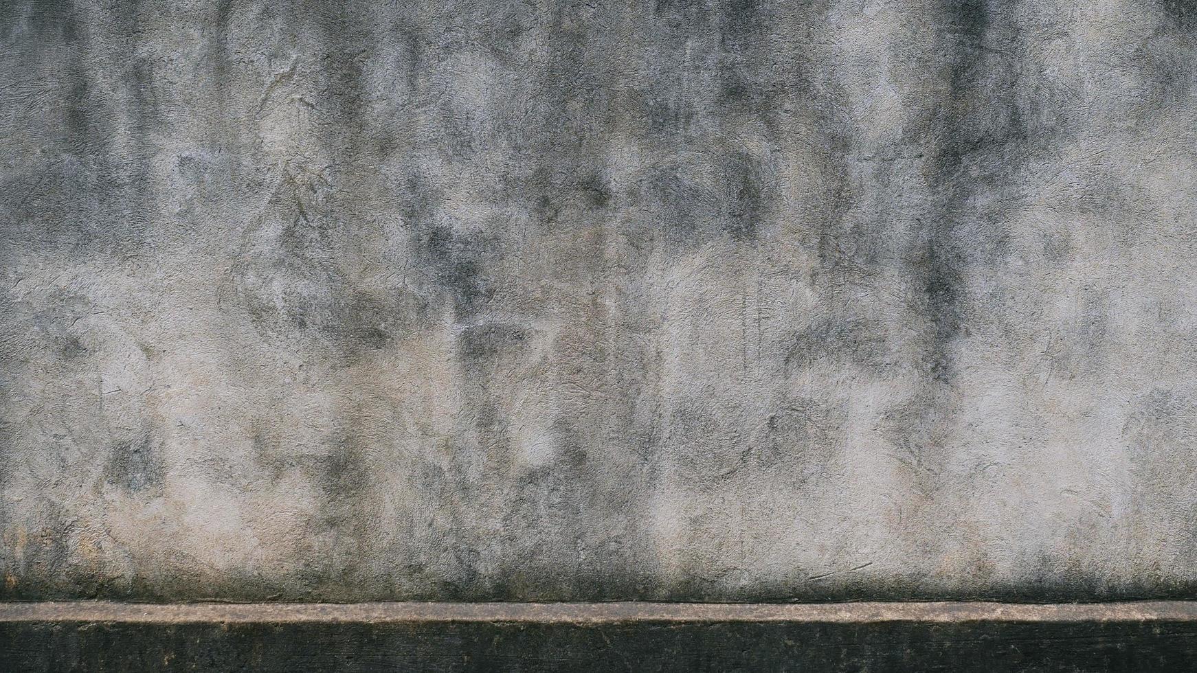 The old cement wall was weathered, the surface was scratched, the surface was scratched and damaged. For a mysterious retro-conservative background. photo