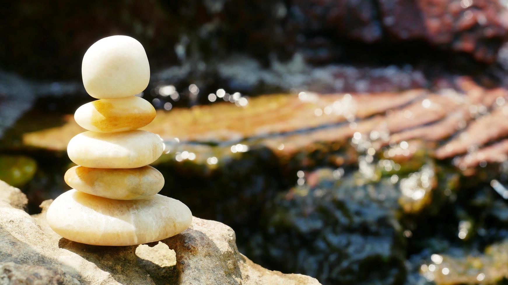 The Balance Stones are stacked as pyramids in a soft natural bokeh background, representing the calm philosophical concept of Jainism's wellness. photo