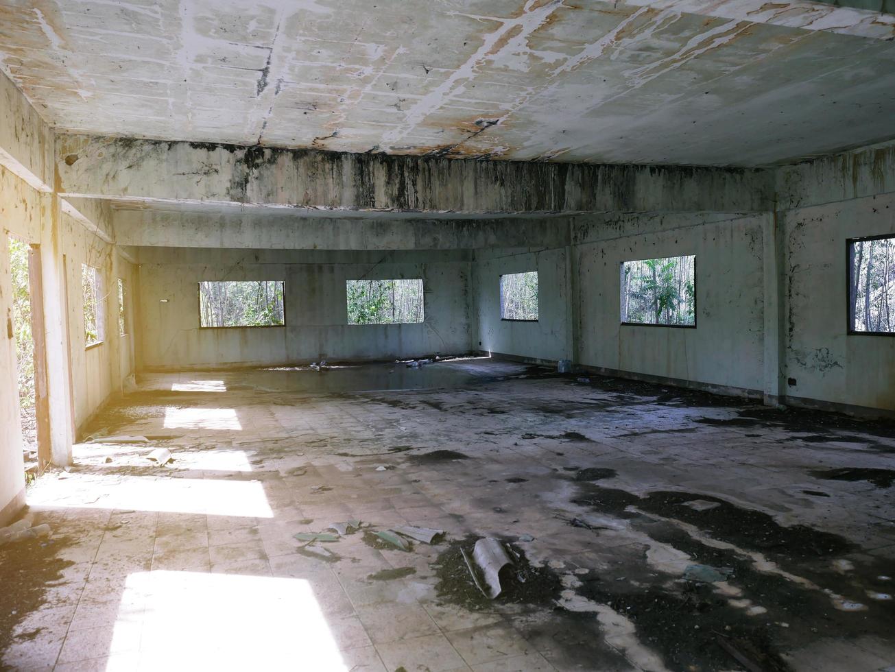 edificio abandonado habitación abandonada con paredes agrietadas y pintura descascarada hay agua dentro del horror. foto