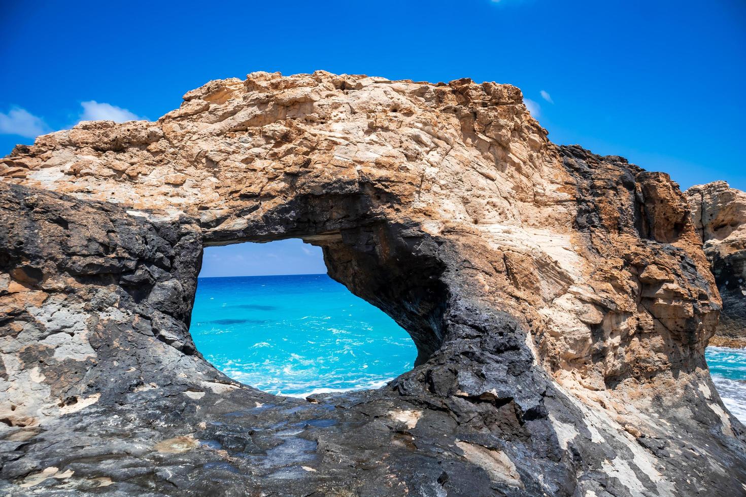 Rock with a big hole in the sea photo