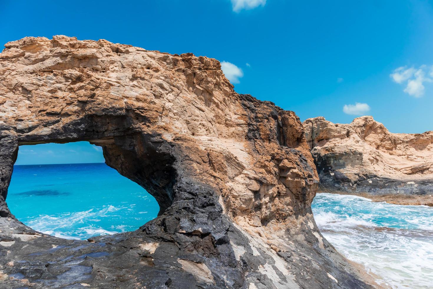 Rock with a big hole in the sea photo