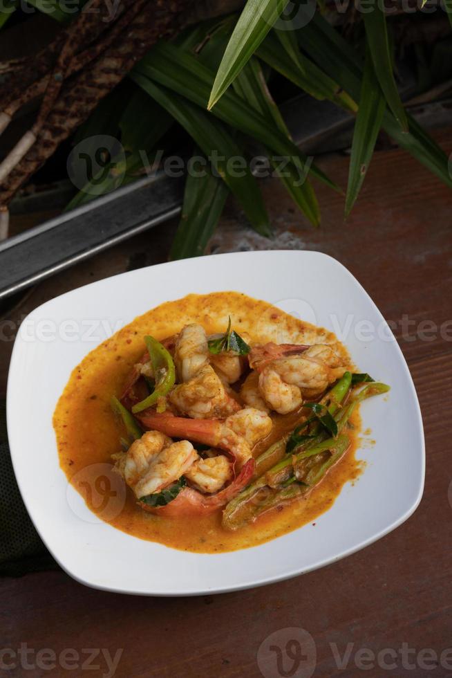 Stir fried shrimp with curry paste in a white plate. photo
