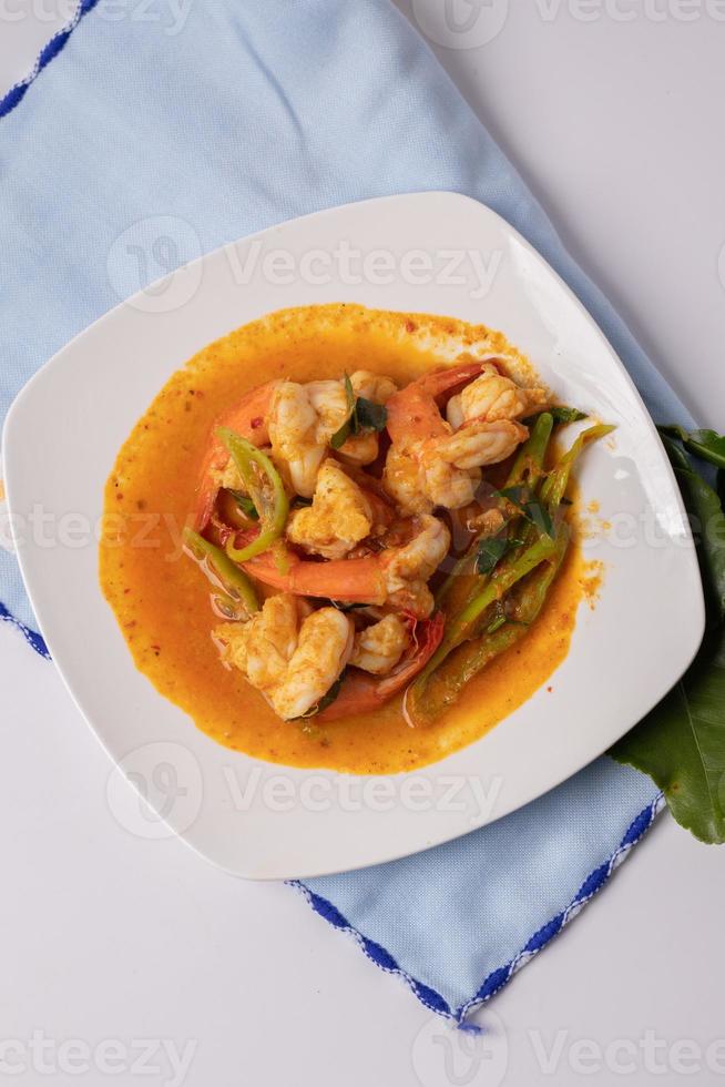 Stir fried shrimp with curry paste in a white plate. photo