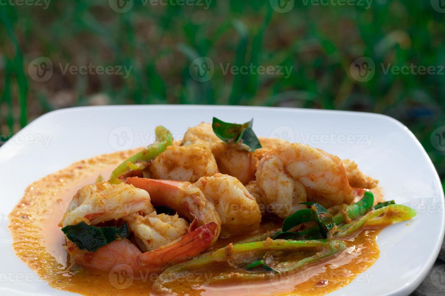 Stir fried shrimp with curry paste in a white plate. photo