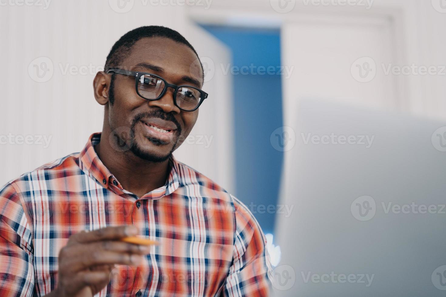 el hombre afro positivo con anteojos tiene una conferencia en línea en la pc. la educación a distancia. cursos online. foto