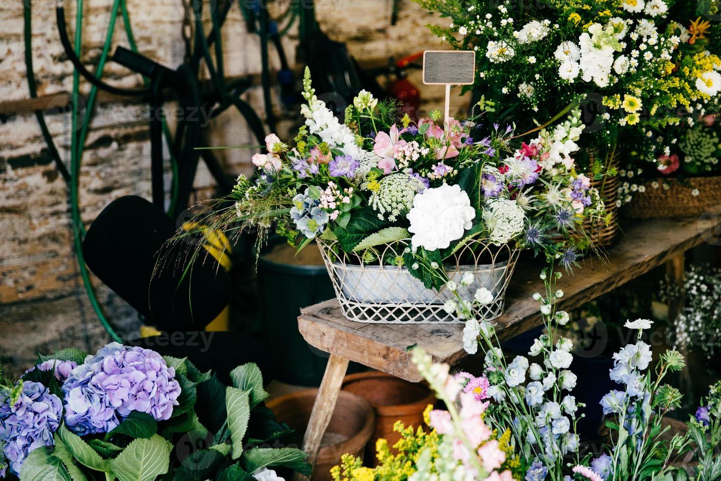 hermosas flores en floristería. diferentes flores maravillosas en respaldos de madera. composición colorida. olores u olores agradables de flores hermosas foto