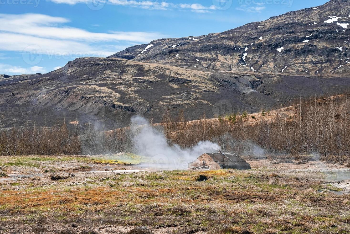Scenic view of geothermal smoking field at Smidur Geyser valley against mountain photo