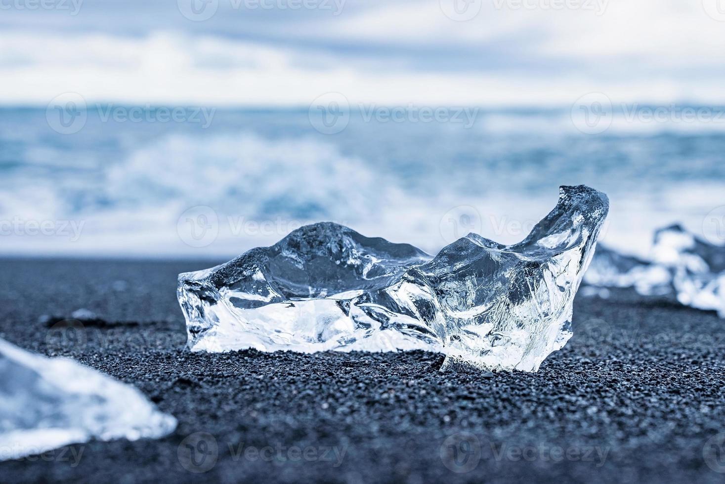 Close-up of shiny ice chunk on black sand shore of Diamond beach photo