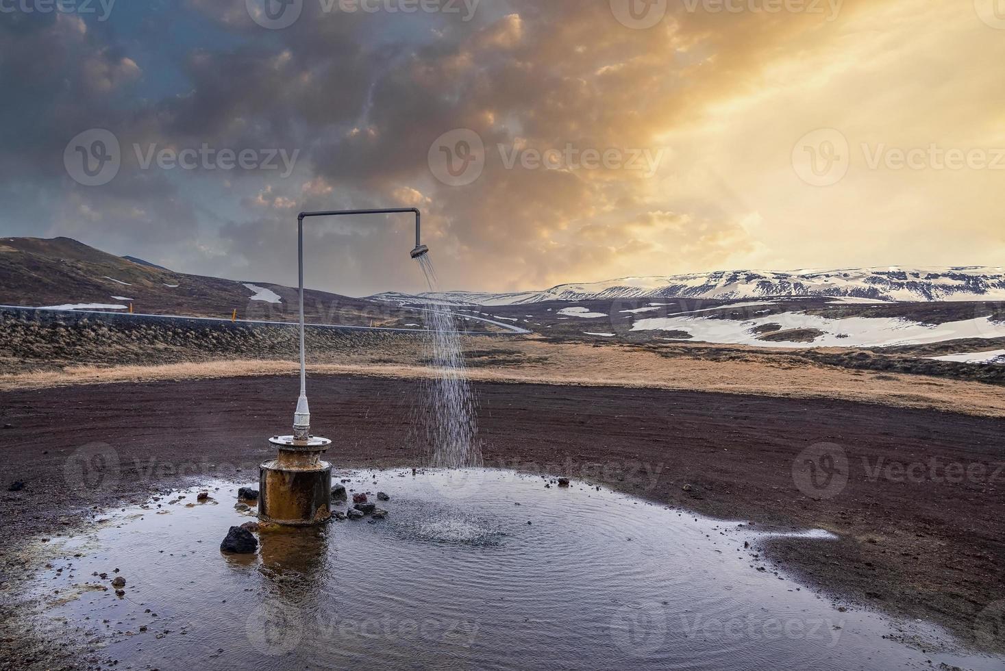 Hot spring shower from geothermal power at Krafla against mountain photo