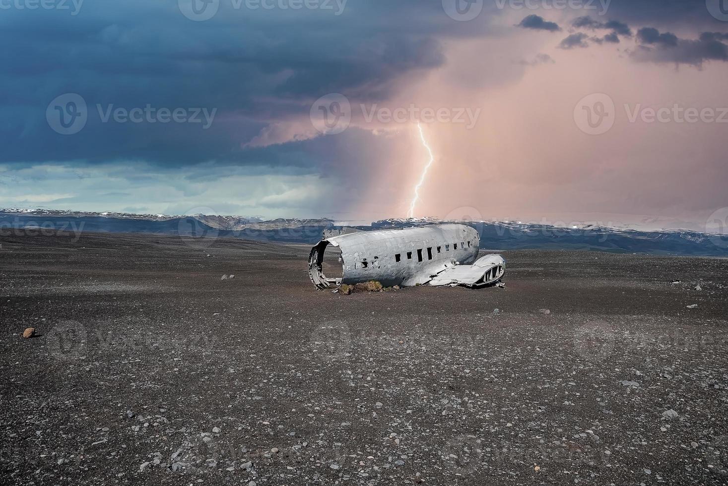 Lightning over broken airplane wreck at black sand beach in Solheimasandur photo